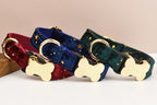 Three velvet dog collars with gold bone-shaped tags on a beige background